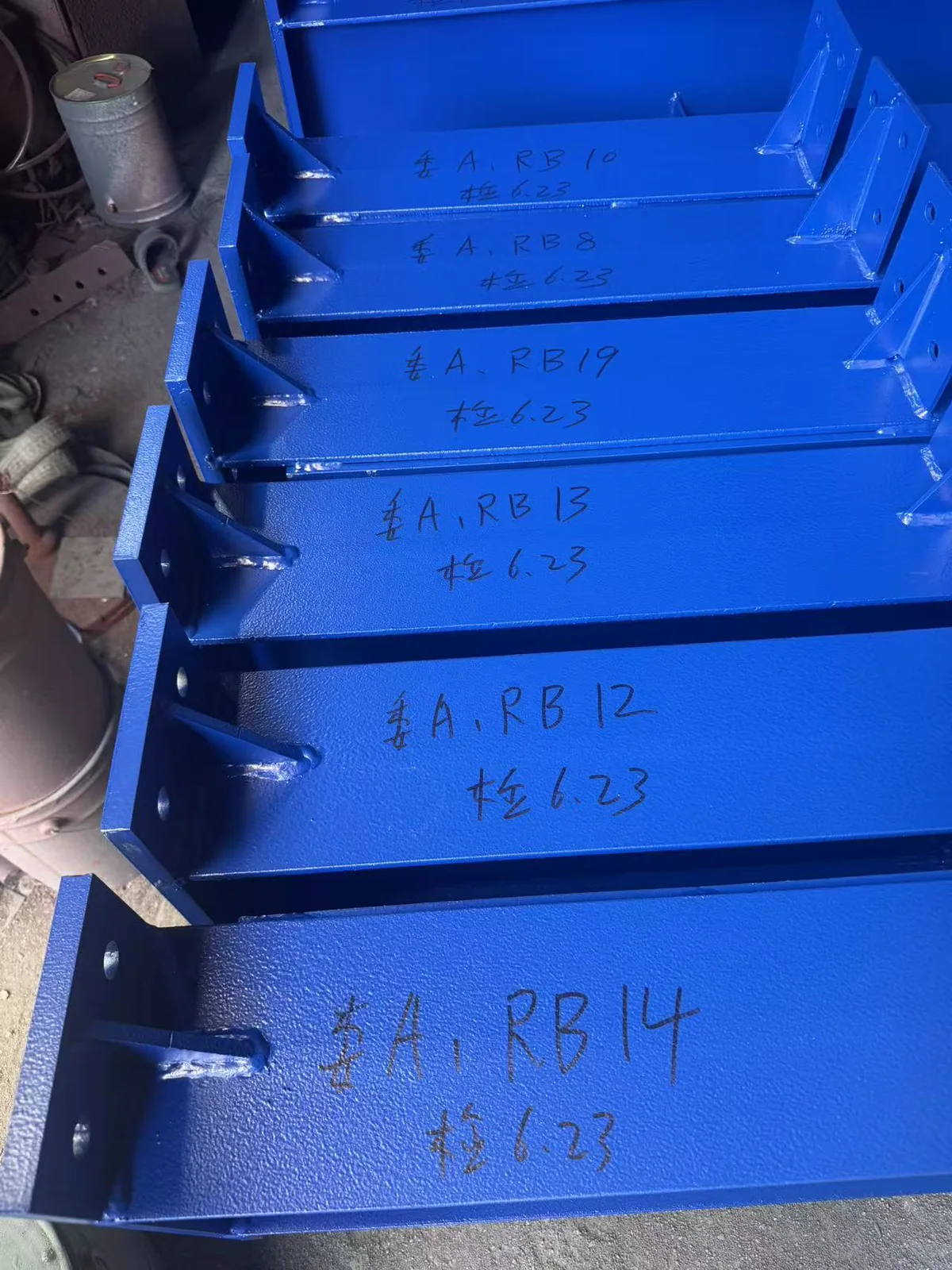 Painted steel components marked for identification before packing