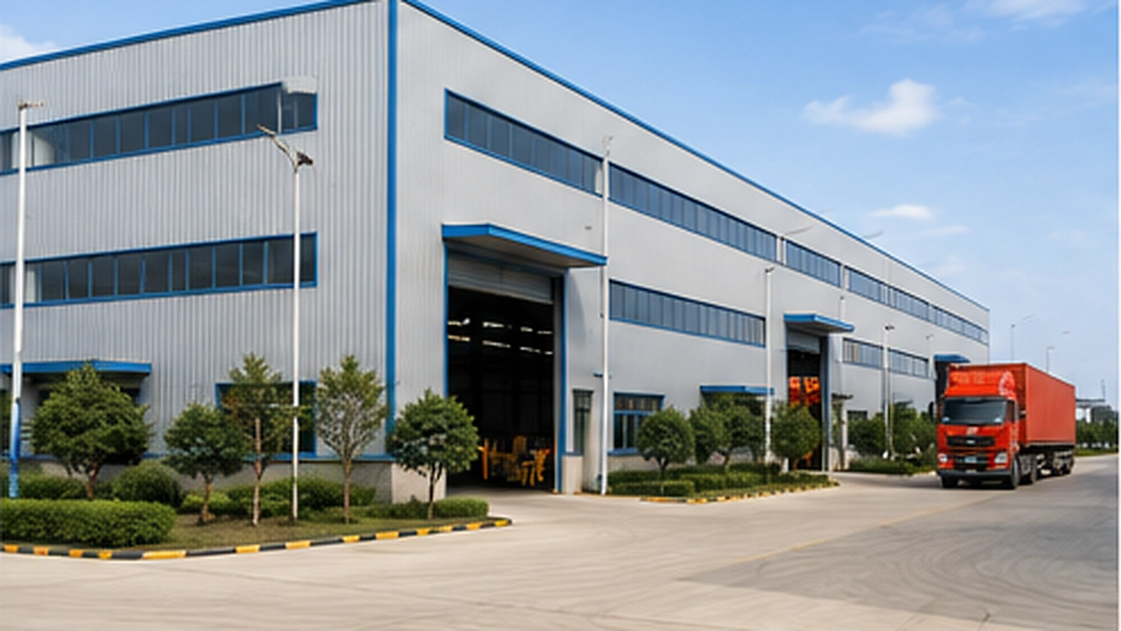 Industrial steel factory building with large equipment access and operational yard